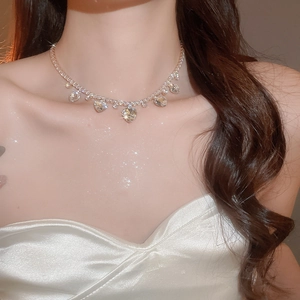 Close-up of sparkling silver zircon heart pendant necklace worn on neck detail