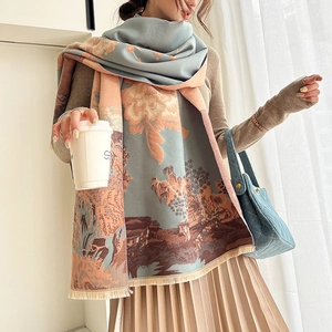 Detail view of woven winter scarf with floral landscape pattern and soft fringed edges