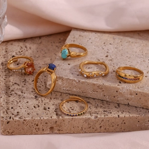 Detail of 18K gold-plated rings set with turquoise and colorful zircon on stone slab