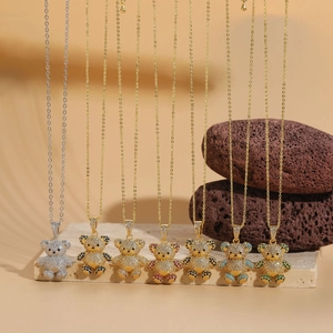 Detail of bear pendant necklaces with colorful zircon stones on marble and volcanic rock