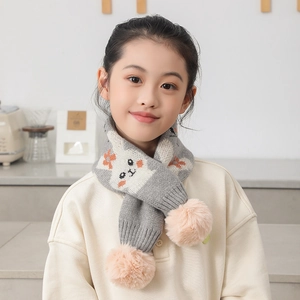 Détail d'une écharpe en maille grise pour enfant avec chat et pompons roses