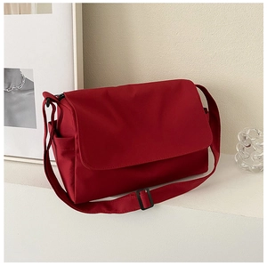 Detail view of burgundy oxford messenger bag with adjustable strap and side pocket