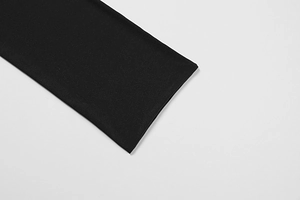Gros plan détaillé des poignets élastiques en maille serrée sur une robe noire en mesh
