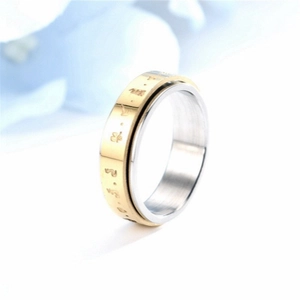 Close-up of rotating stainless steel anxiety ring with gold embossed religious symbols