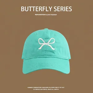 Detail of teal cotton canvas sun hat featuring exquisite white butterfly embroidery