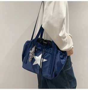 Close-up of blue water-resistant nylon tote bag with large white star and drawstring detail