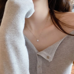 Detail showing a sparkling cubic zirconia pendant necklace worn on a female neck
