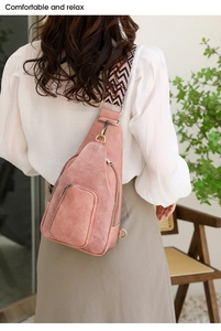 Detail der rosa Brusttasche aus Wildlederimitat mit gewebtem Gurt und Metall-Zippern