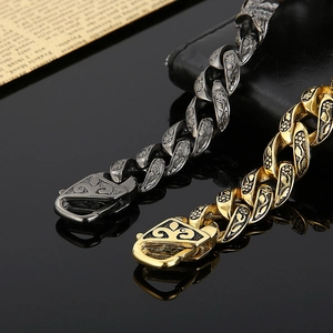 Detailed macro view of vintage gold and silver engraved Cuban link bracelets on black surface