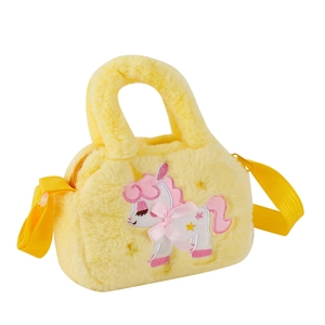 Dettaglio della borsa in peluche gialla con ricamo a forma di unicorno rosa e fiocco rosa