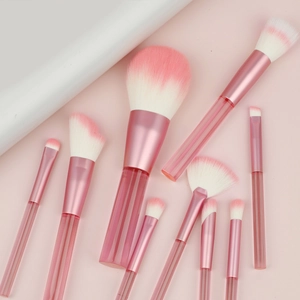 9-piece pink transparent handle makeup brush set with gradient bristles on pink background