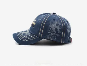 Detail view of washed navy denim baseball cap with beige stitching and vintage embroidery