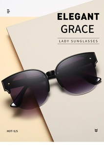 Detailed close-up of cat-eye sunglasses with gold rivets and gradient lenses on grey card