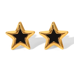 Detail of gold star earrings with black inlay and polished stainless steel texture