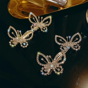 Sparkling rhinestone butterfly hair clips set with gold-tone finish on a luxury black base