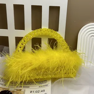 Detailed close-up of yellow beaded handbag featuring luxury ostrich feather trim and handle
