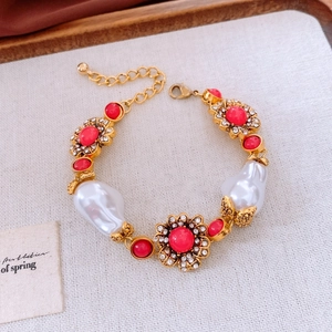 Detail eines Vintage Goldarmbands mit rotem Edelstein und barocken Perlenelementen