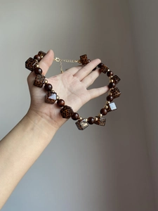 Detail view of retro leopard print square beads and brown round beads on necklace