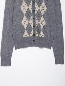 Detailed view of argyle knit cardigan with gray patterns and ribbed texture details