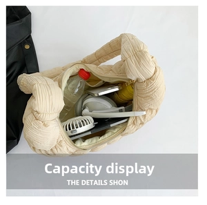 Top view of large capacity beige pleated puffer bag showing spacious interior with daily items
