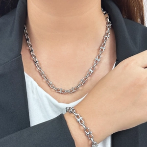 Bowknot silver industrial chain necklace and bracelet set shown on model in suit