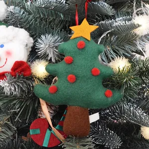 Felt Christmas tree ornament with yellow star and red pom-poms on festive pine branch