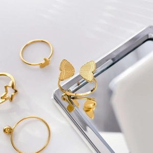 Detailed close-up of 18K gold plated titanium rings featuring butterfly and star motifs