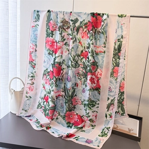 Detail of floral silk scarf with vibrant red and blue patterns draped on a stand