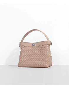 Close-up of woven leather texture and silver metal twist lock on the handbag