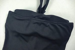Detail of black elastic fabric showing backless lace-up ties and double-stitched edges