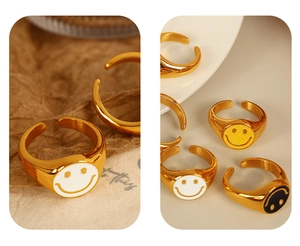 Macro shot of 18K gold plated smiley face rings in white, yellow and black enamel colors
