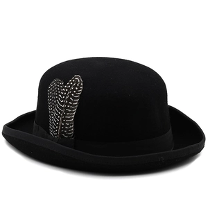 Detailed view of black wool felt bowler hat with spotted feathers and grosgrain ribbon