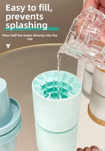 Pouring water into a mint green silicone ice cylinder mold on a mirrored table surface