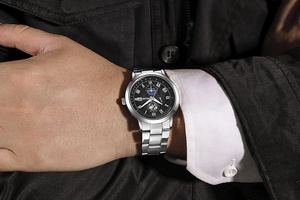 Primo piano di orologio da uomo in acciaio inox con quadrante nero a tre occhi