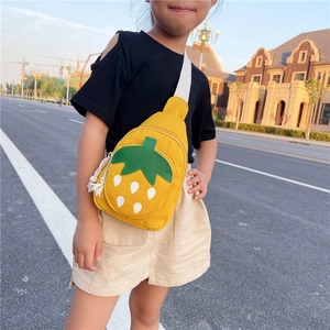 Close-up of yellow canvas kids chest bag with strawberry pattern and white wide strap