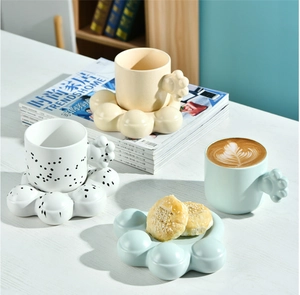 Detail of chubby handle ceramic mug with bubbly saucer and snack plate in cream and blue
