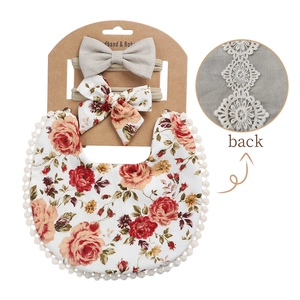Detail of floral baby bib and headband set with lace trim and vintage rose pattern