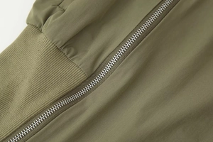 Vue détaillée de la veste vert armée avec fermeture éclair argentée et poignets côtelés