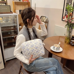 Trousse à cosmétiques matelassée blanche avec motifs ours tenue dans un cadre de café