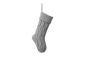Detail of grey knitted Christmas stocking with cable stitch pattern and hanging loop