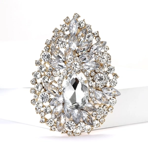 Detailed close-up of a large gold alloy brooch with sparkling teardrop rhinestones