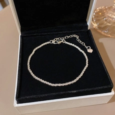 Detailed macro of silver popcorn chain bracelet with heart charm and extension links