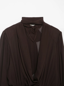 Detail of dark brown halter neck dress with cutout chest design and pleated textures