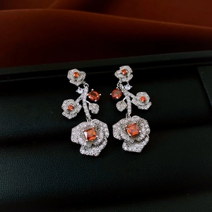 Detailed macro of vintage rose earrings with orange stones in a black leather gift box