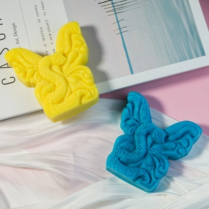 Dettaglio di stampi per candele a farfalla gialli e blu con trame in rilievo di drago