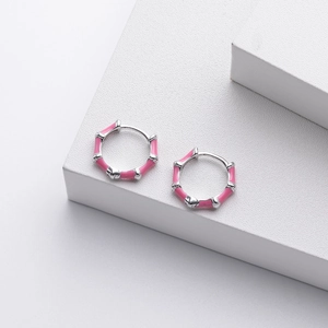 Detailed view of pink bamboo style hoop earrings with silver finish and enamel on stand