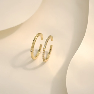 Close-up of dual gold adjustable rings featuring minimalist solitaire and pavé-set zircons