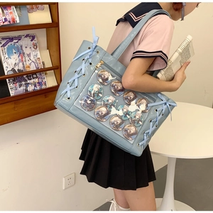Detail view of light blue Ita bag with clear window and ribbon decor for anime badges