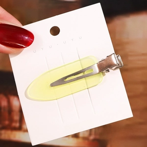 Detail shot of a 6cm yellow translucent acetate hair clip with a silver metal duckbill base