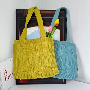 Close-up of ginger and blue knit tote bags featuring geometric hollow textures and wide straps